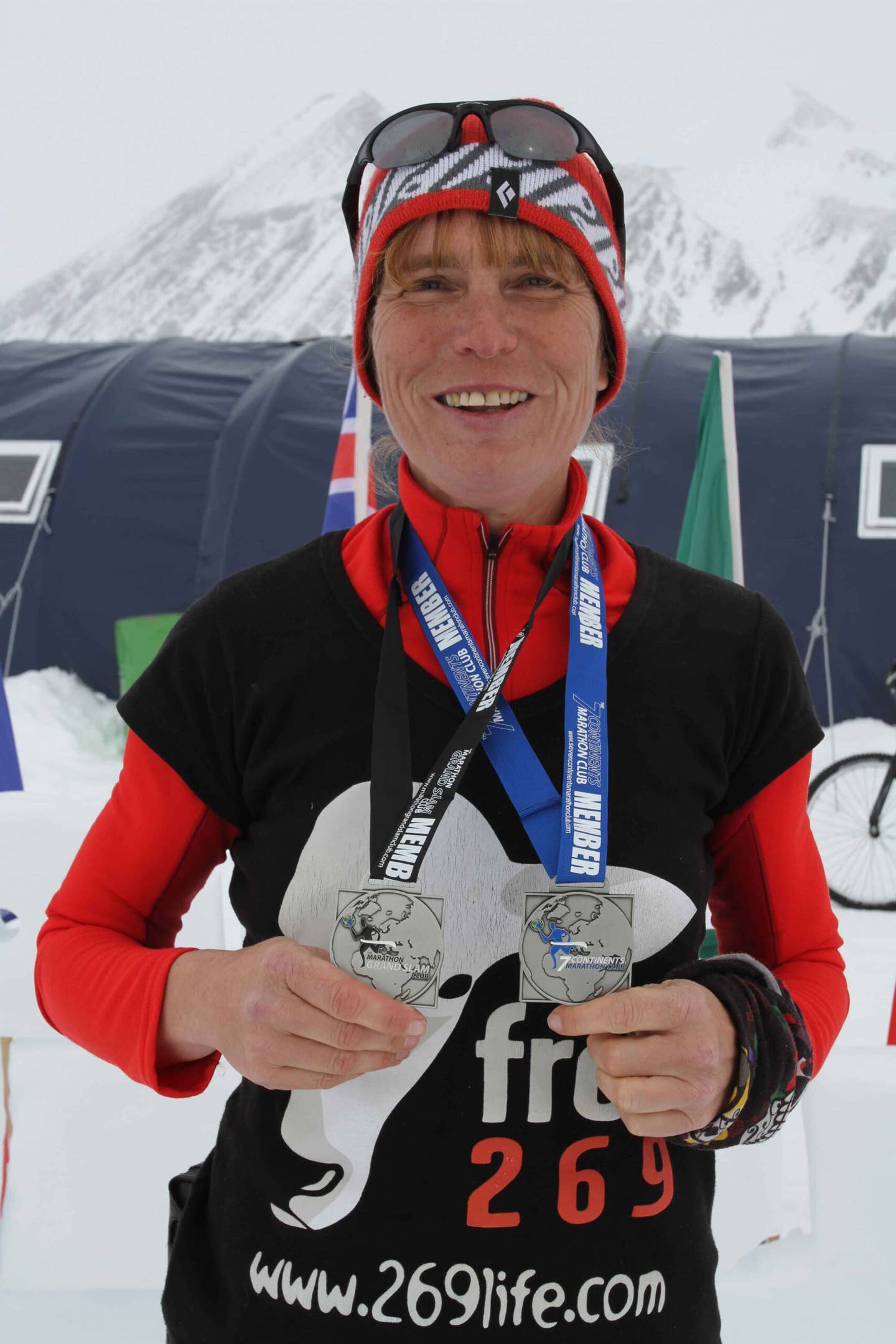 fiona oakes holding her world record medals after completing a marathon on every continent