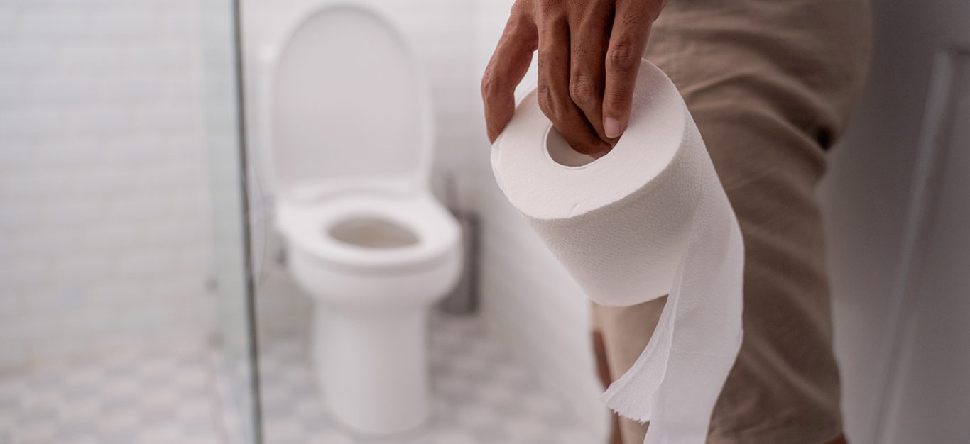 Man holding toilet paper with toilet shown in background - photo accompanies article with tips on vegan colonoscopy prep