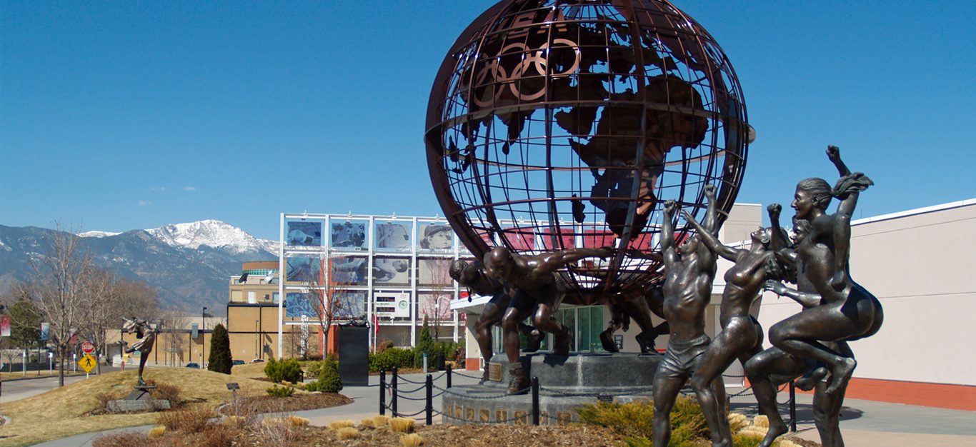 The courtyard outside the U.S. Olympics and Paralympics Committee Headquarters in in Colorado Springs, with a large metal globe sculpture and four sculptures of athletes jumping