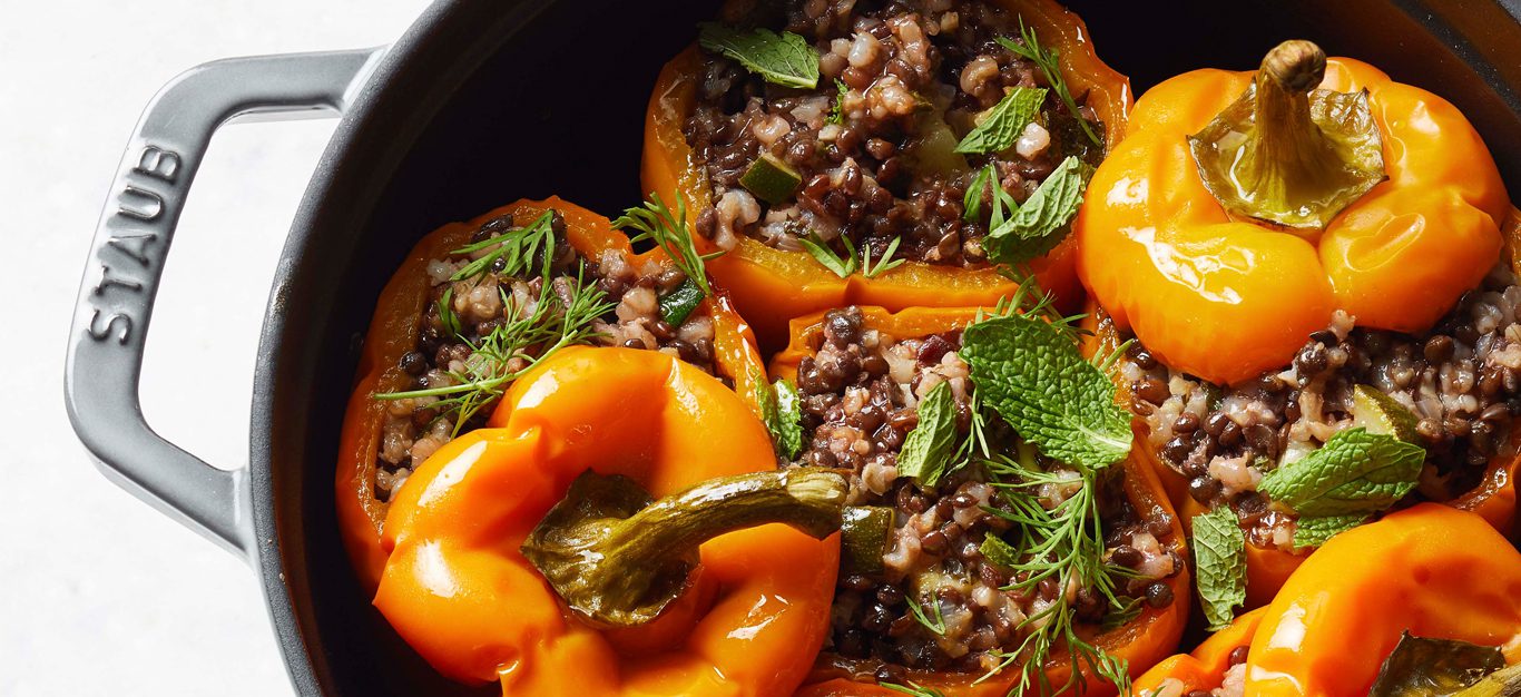 Vegan Stuffed Bell Peppers with Lentils and Herbed Rice in a cast iron skillet