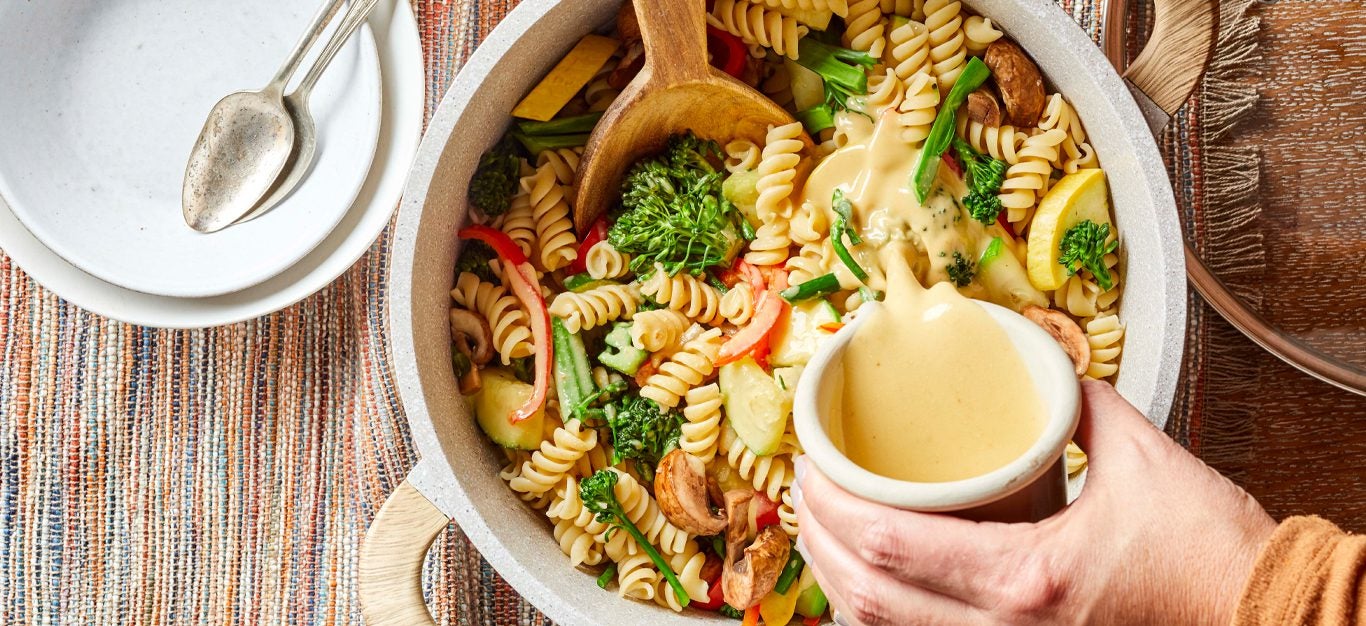 One-Pan Creamy Pasta with Broccolini with a creamy sauce being poured over it
