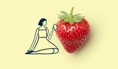 A cartoon woman sitting beside a strawberry