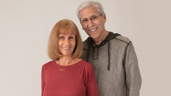 An older couple shown standing together and smiling, with a plain background. Fran German, on the left, suffered from myasthenia gravis for years