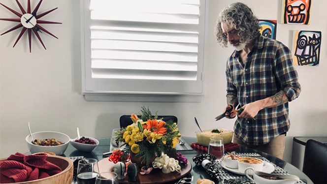A man stands beside a vegan Thanksgiving spread