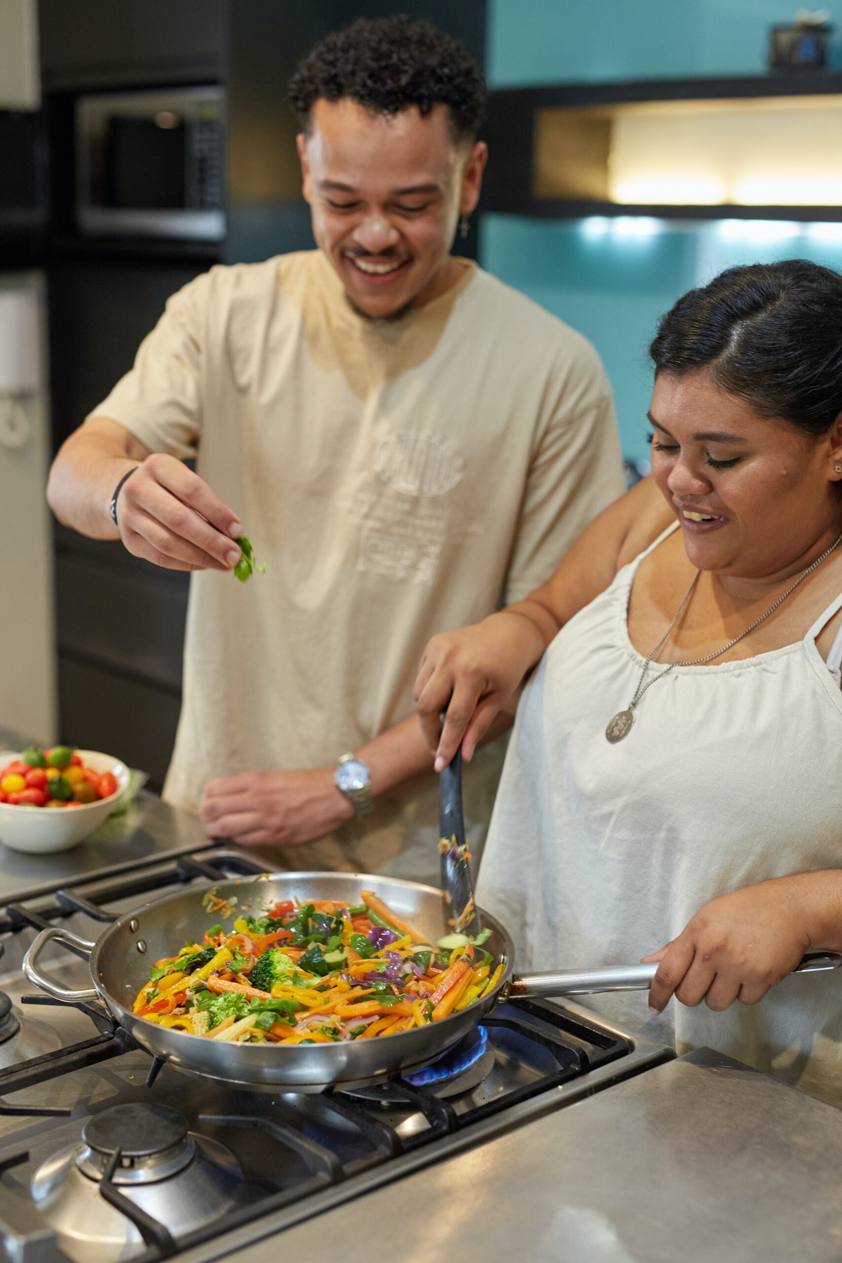 man and woman sauteeing vegetables