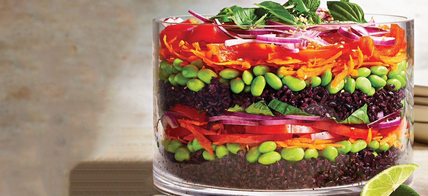 Layered Black Rice Salad in a large glass serving bowl