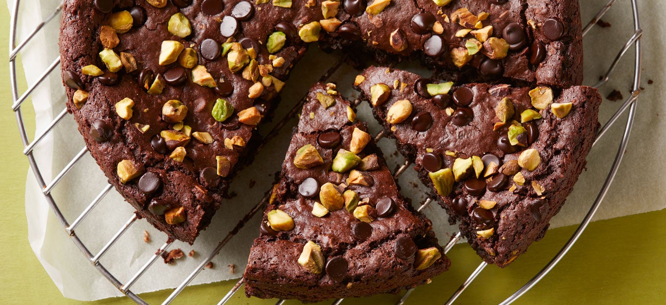 Healthy black bean brownies by Chef AJ, shaped like a pie and cut into slices, garnished with pistachios