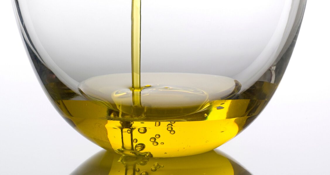 Fresh olive oil pouring into a bowl