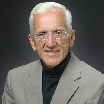 T. Colin Campbell, PhD, in a suit on a gray background