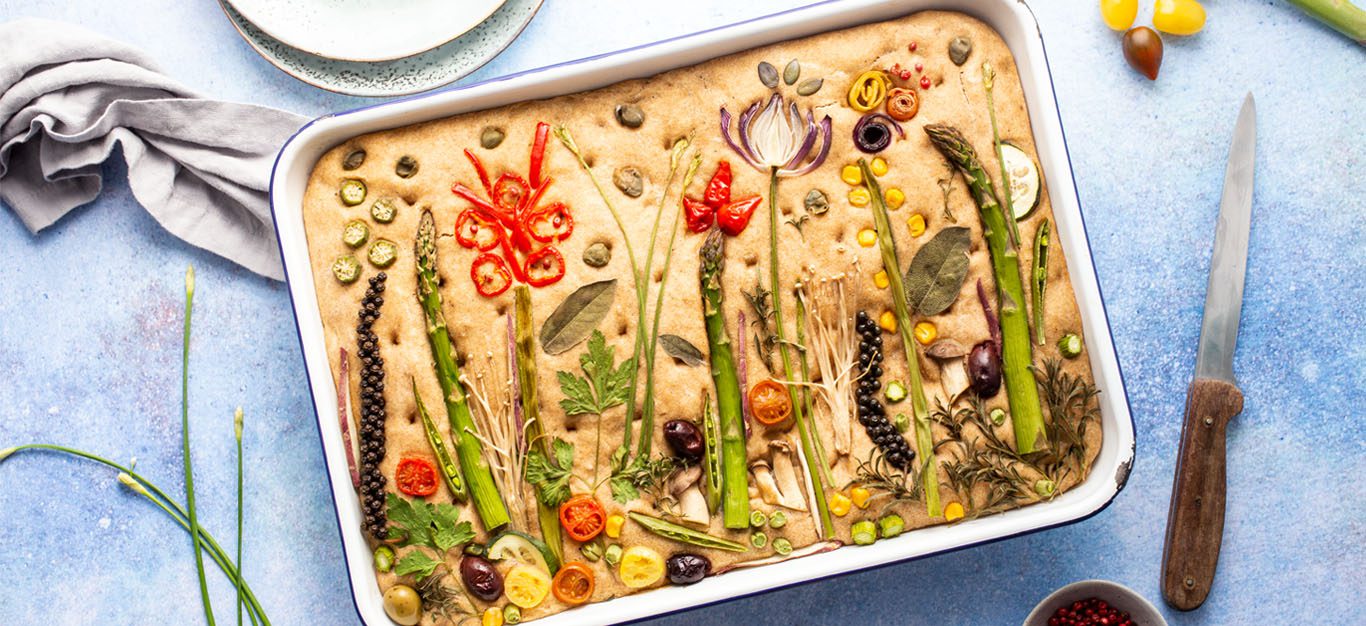 Festive Oil-Free Sourdough Focaccia Bread - An 8x13 focaccia decorated with herbs and vegetables to make a springtime landscape