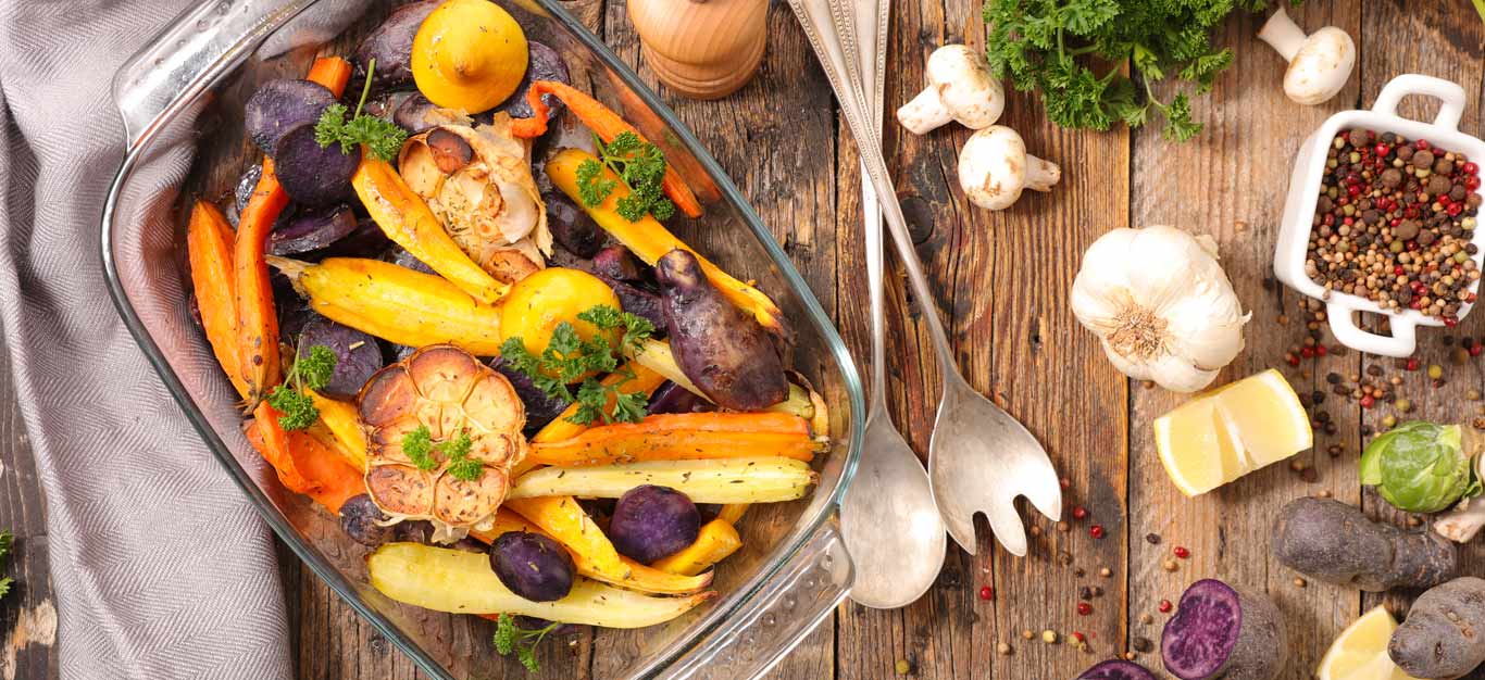 A casserole dish of carrots and other root vegetables roasted without oil