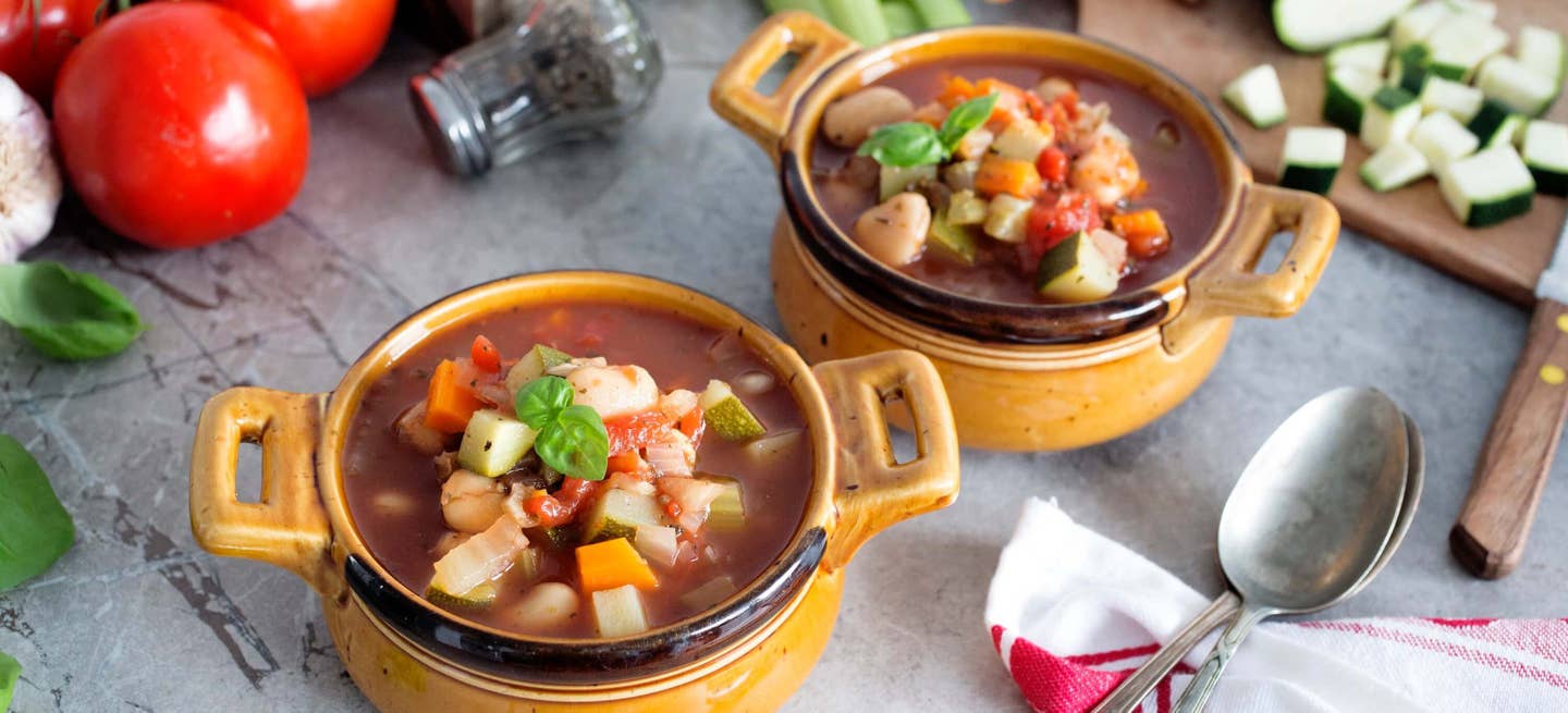 Two bowls of vegan minestrone on a table