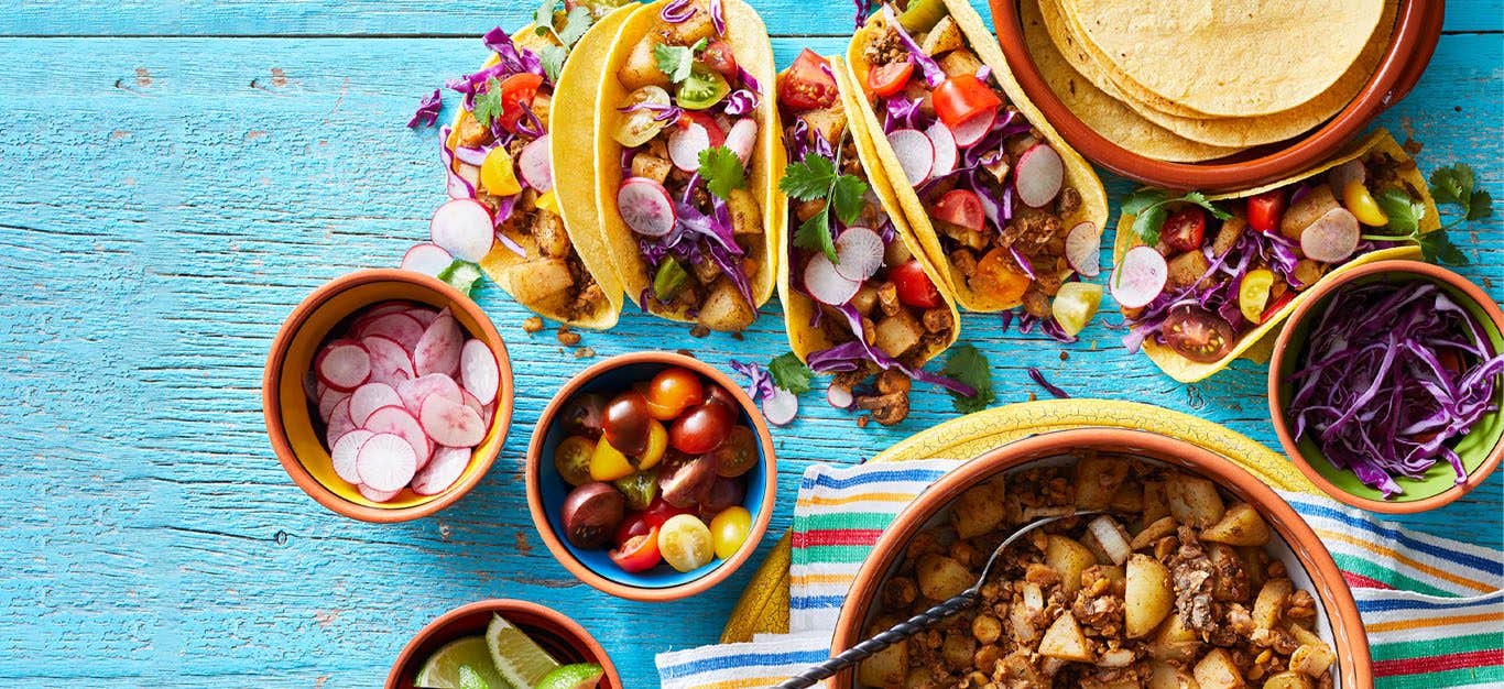 Plant-based tacos with a mushroom chorizo filling served on a blue table
