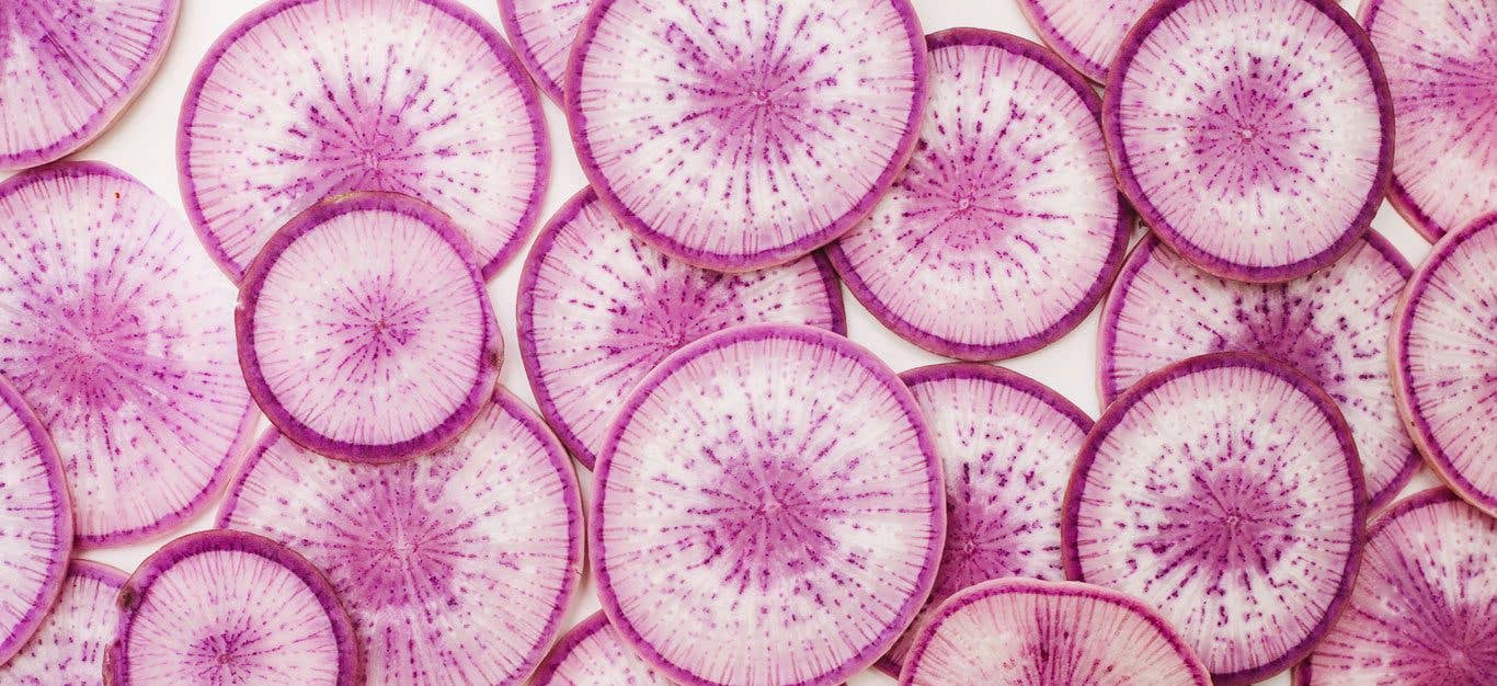 A close up view of thinly sliced radish slices overlapping