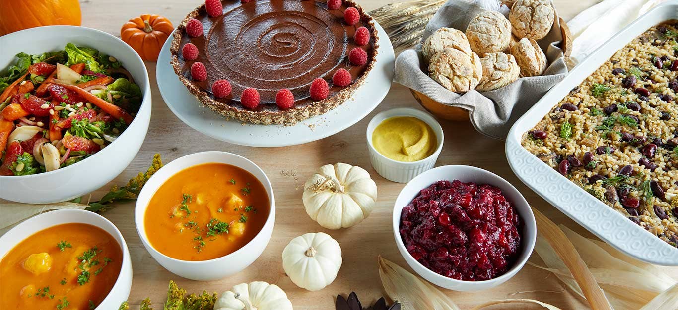 a vegan Thanksgiving tablespread including a rice casserole and chocolate pie and dinner rolls