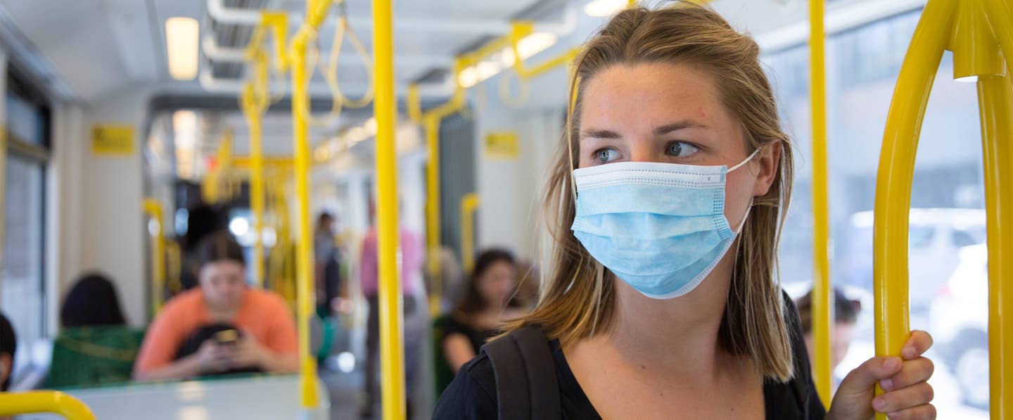 image shows a woman on a bus wearing a mask during covid-19 pandemic - zoonotic diseases