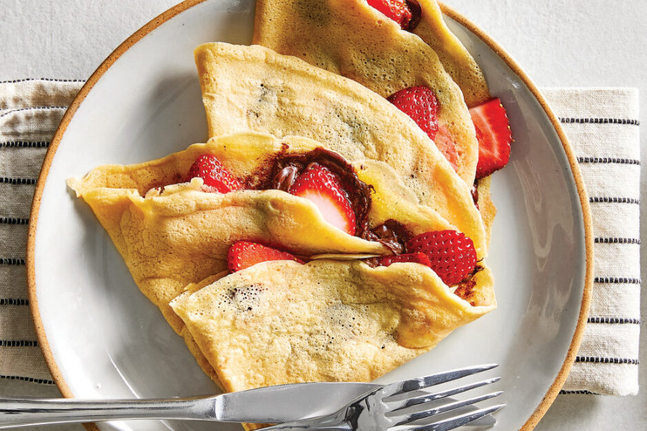 Gluten-Free Crepes stuffed with strawberries on a white ceramic plate