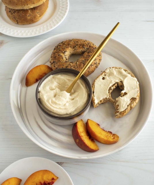 Whole grain bagels spread with homemade vegan cream cheese by Brandi Doming