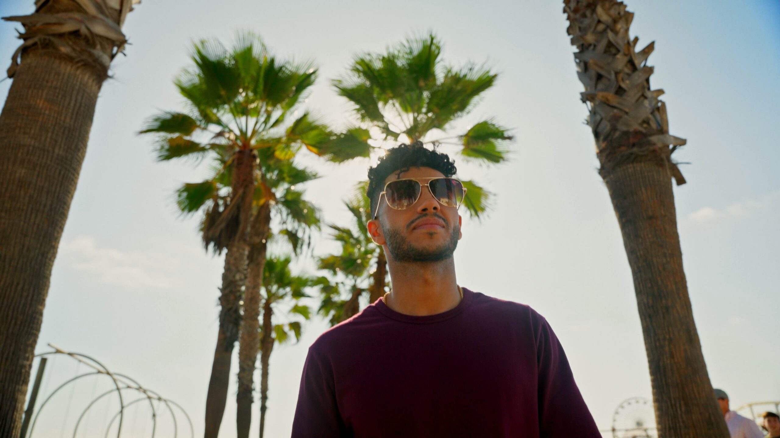 Mena Massoud walks down a los angeles street in a still from his show evolving vegan