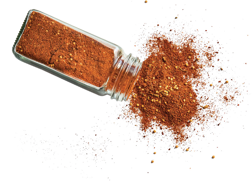 A clear glass jar of Pepperoni Seasoning rom the Local Spicery spilling out onto a white background f