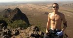 Runner Brandon Frye stands on a rocky overlook on a sunny day