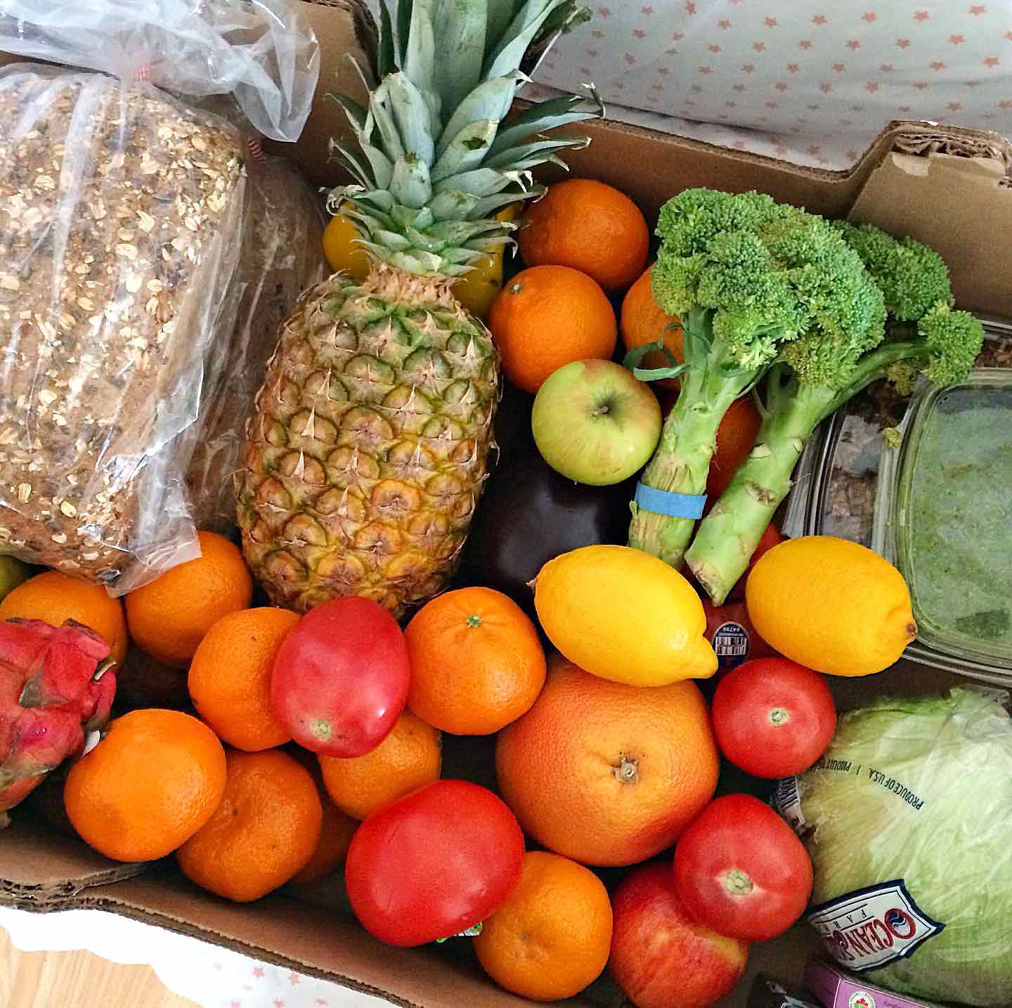 A box full of fresh produce, whole grain bread, and other vegan pantry items awaits delivery