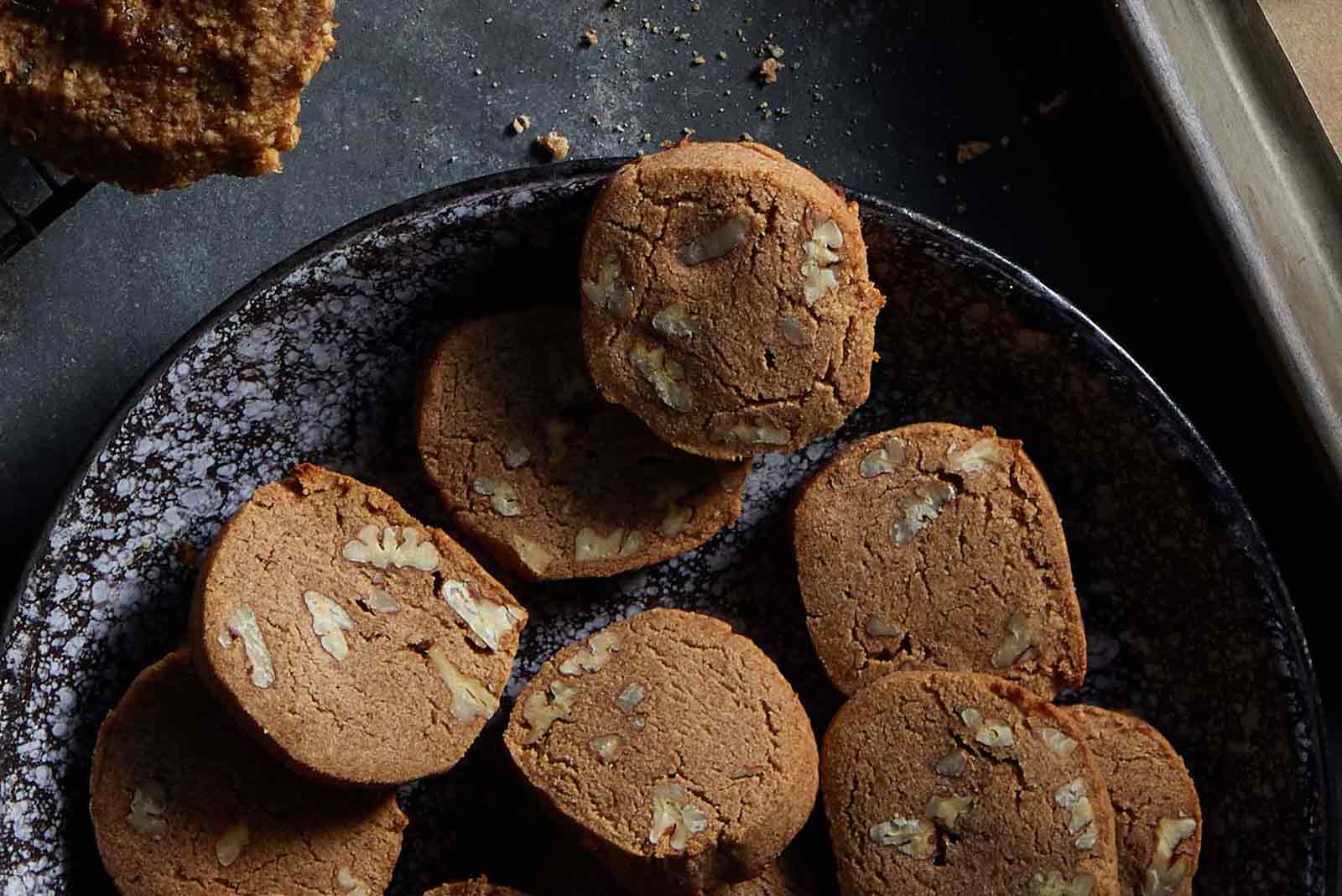 Vegan gluten-free pecan short-bread cookies on a dark background