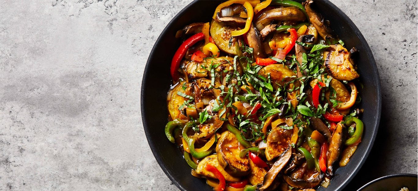 Thai Basil Eggplant in a dark blue bowl on a gray countertop