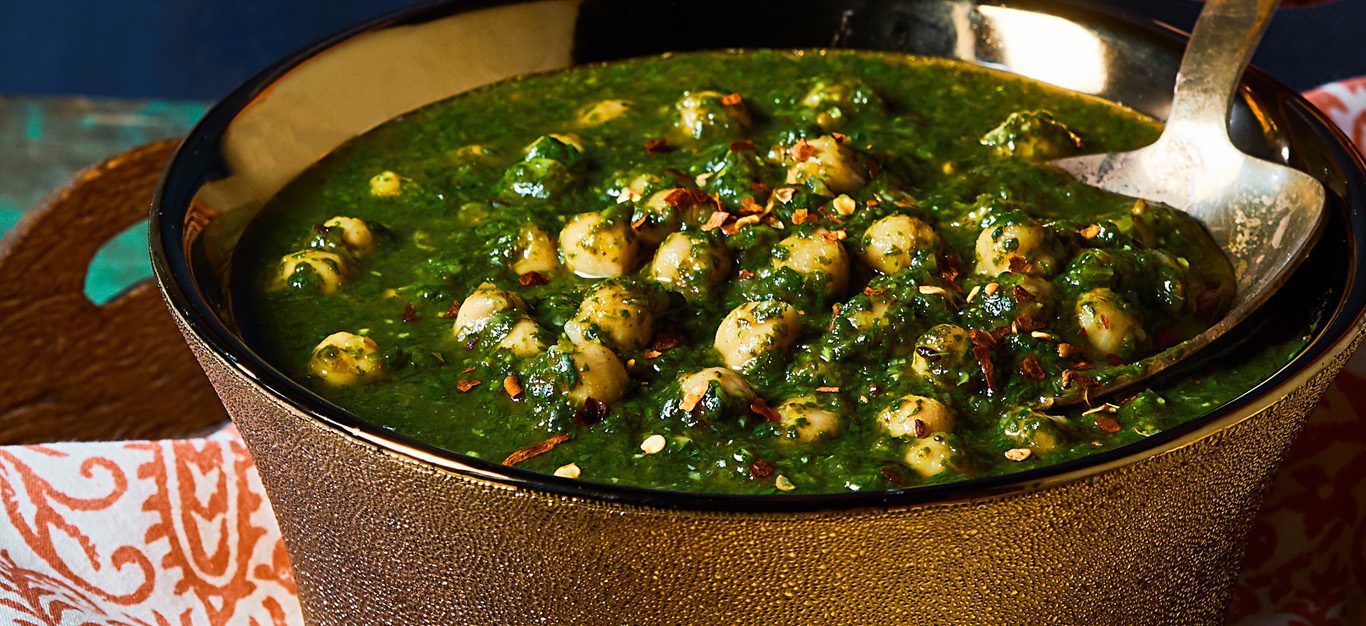 Vegan saag with chickpeas shown in copper bowl