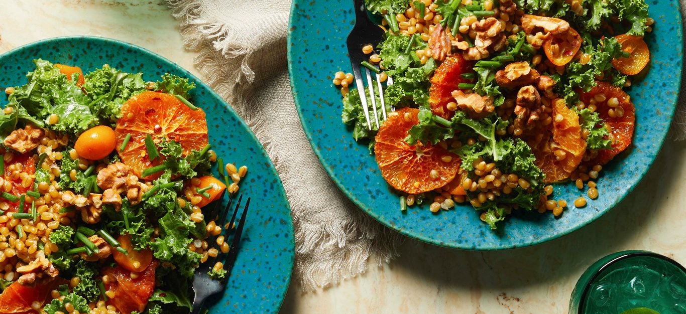 Hearty Kale Salad with Warm Citrus and Wheat Berries on blue plates
