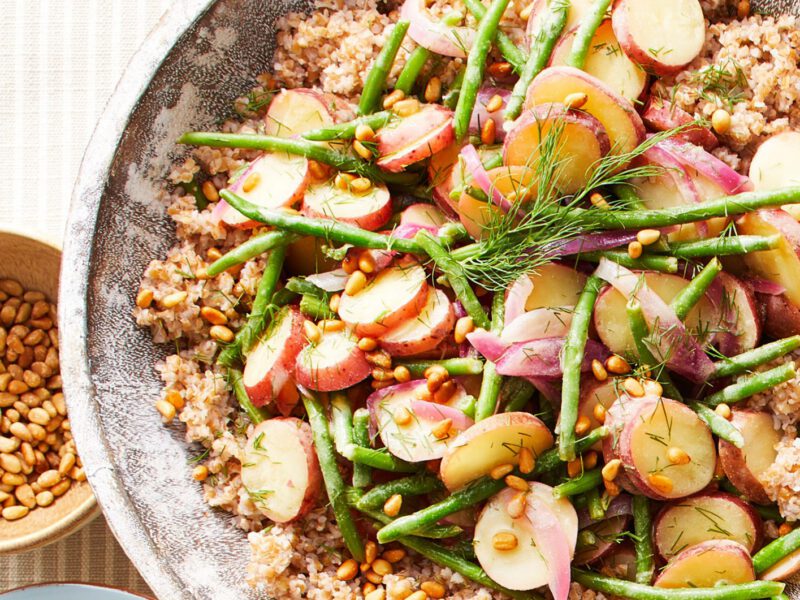 A bowl of cooked bulgur wheat with green beans, new potatoes, and mustard vinaigrette