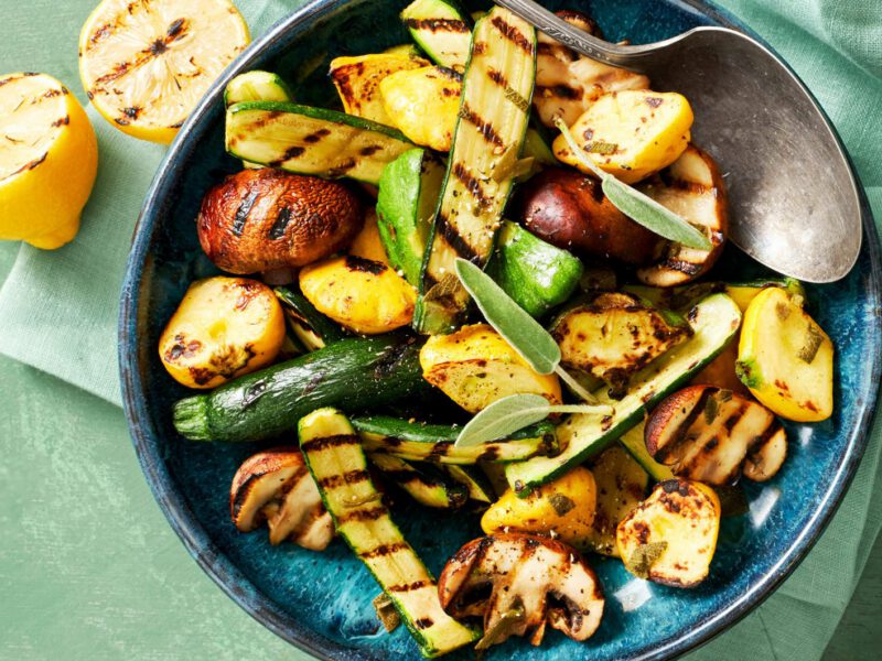A top-down view of a bowl of Grilled Squash and Mushrooms with Fresh Herbs