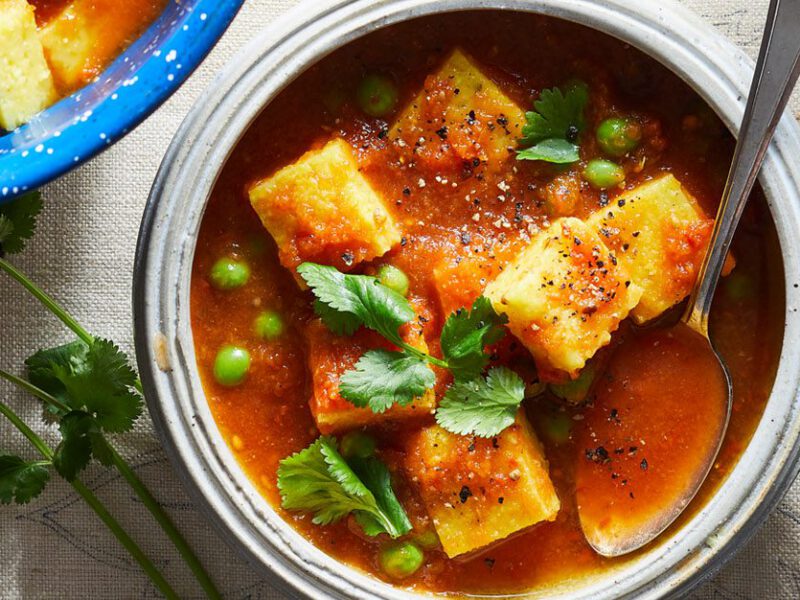 Polenta Curry - Hearty red stew with cubes of polenta and green peas and other veggies