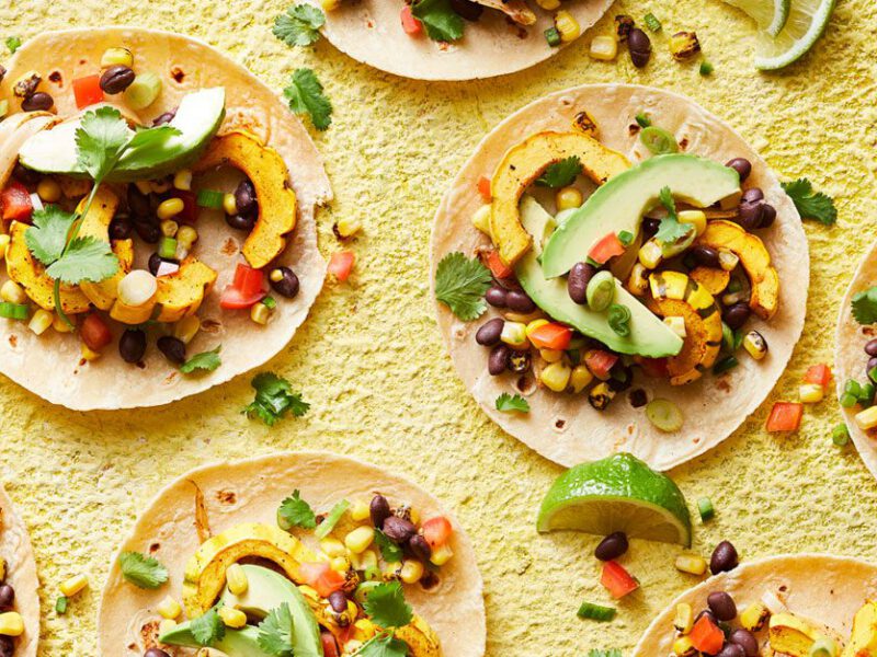 delicata squash tacos with avocado on a yellow surface