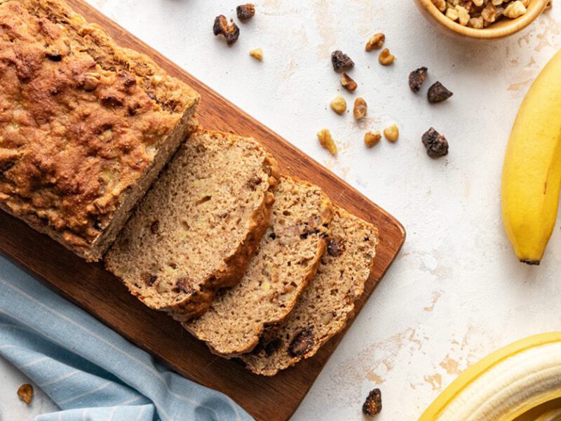 vegan banana bread sliced shown with dried figs and whole bananas