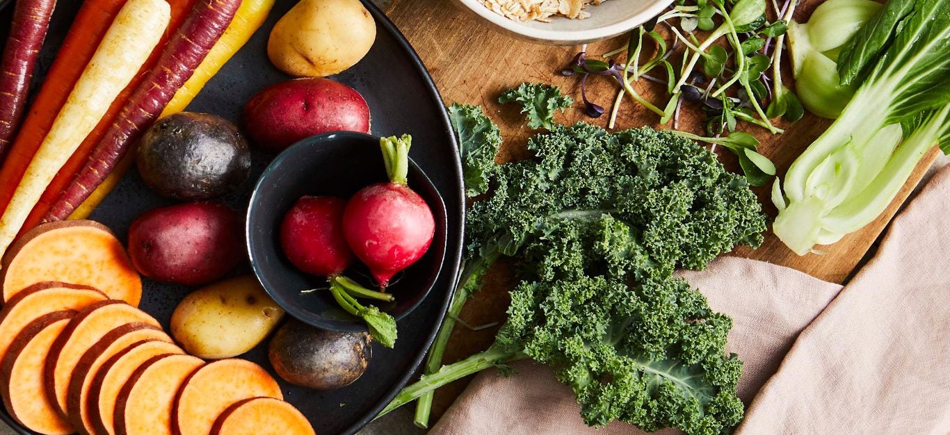 fall and winter fruits and veggies - kale, beets, sweet potato shown on wood table