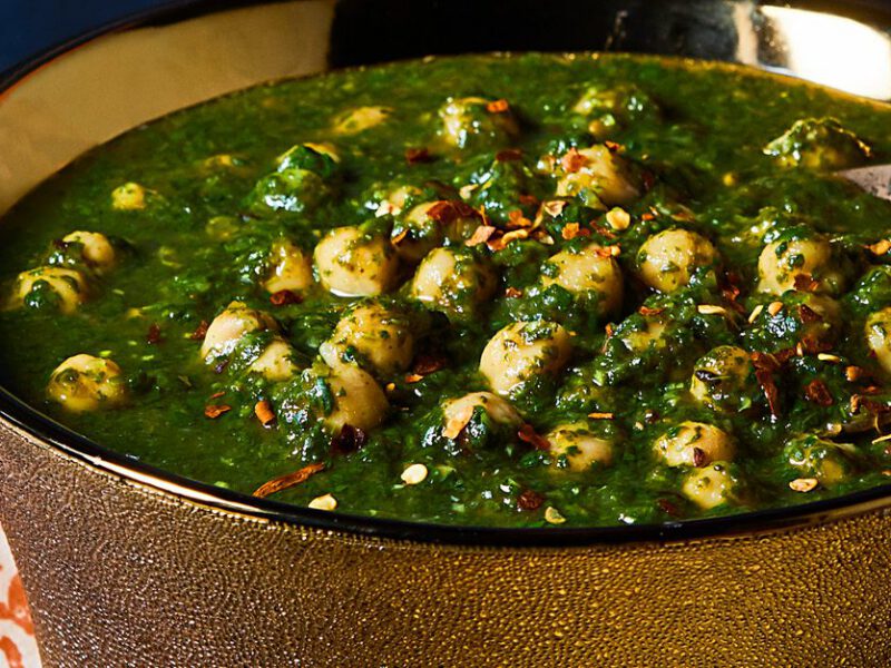 Vegan saag with chickpeas shown in copper bowl