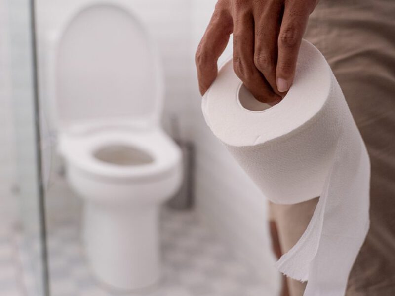 Man holding toilet paper with toilet shown in background - photo accompanies article with tips on vegan colonoscopy prep