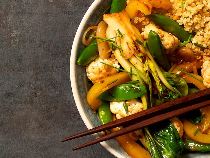 Five-Spice Stir-Fry in a wide-rimmed serving bowl with chopsticks resting across