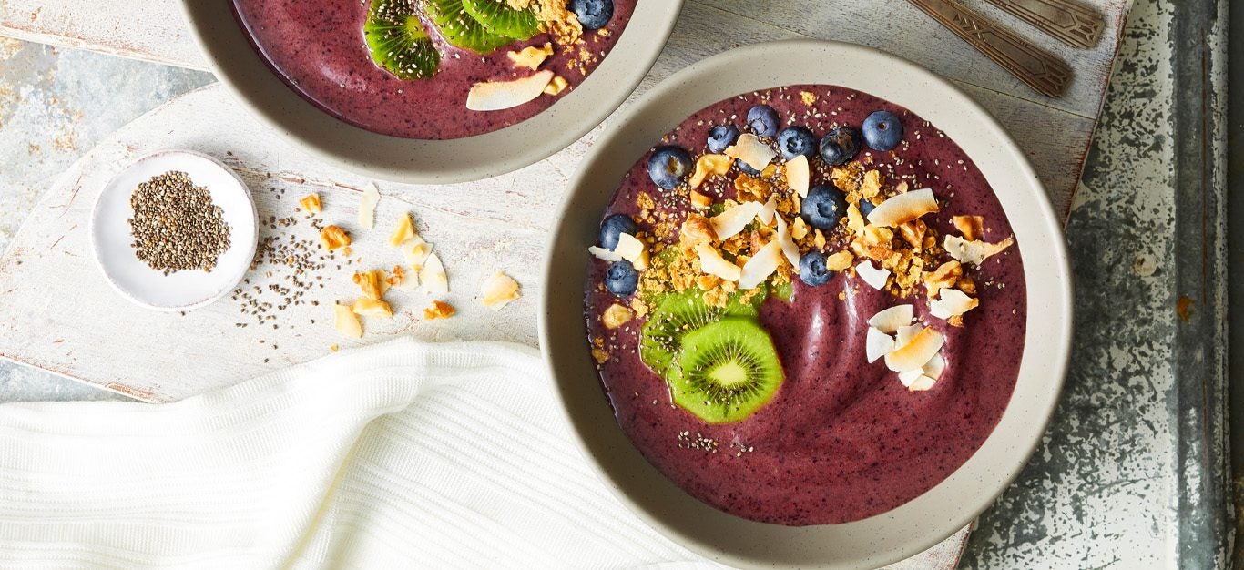 Berry and Banana Smoothie Bowls - Purple smoothie blend served in bowls, topped with kiwi and coconut