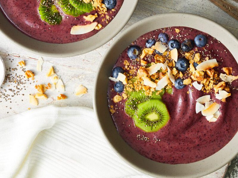 Berry and Banana Smoothie Bowls - Purple smoothie blend served in bowls, topped with kiwi and coconut