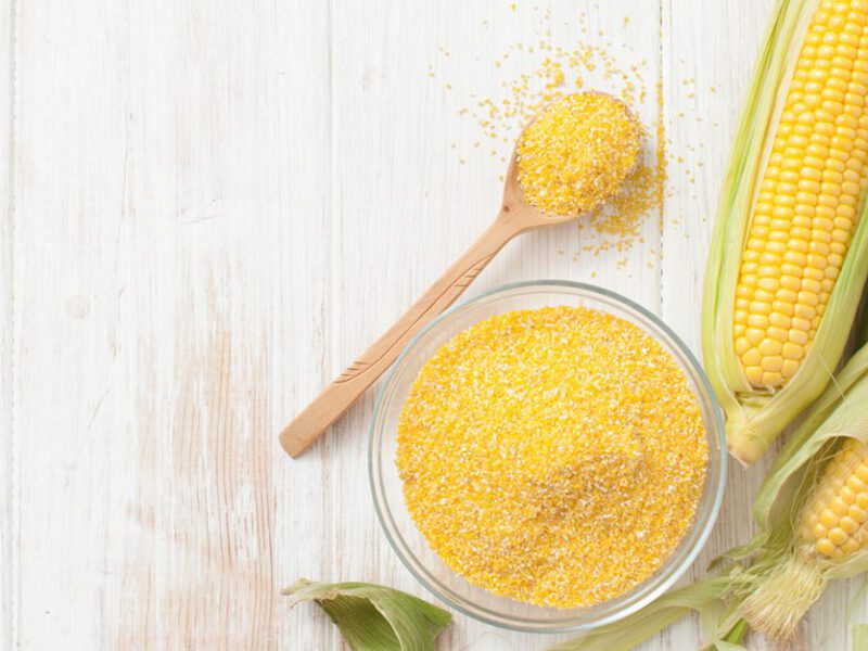 polenta cornmeal and corn on the cob shown on a white table