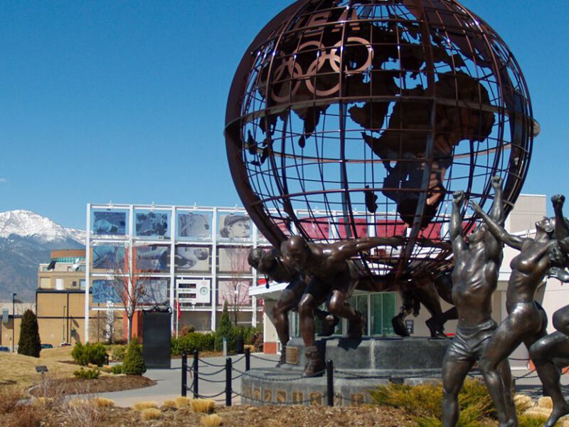 The courtyard outside the U.S. Olympics and Paralympics Committee Headquarters in in Colorado Springs, with a large metal globe sculpture and four sculptures of athletes jumping