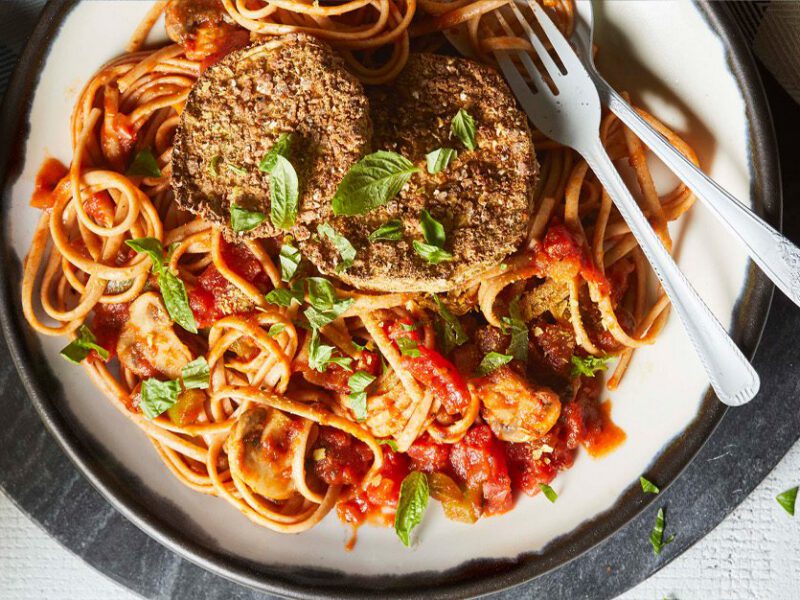 air-fryer eggplant parmezzan - breaded and fried slices of eggplant atop a spaghetti dish with marinara sauce