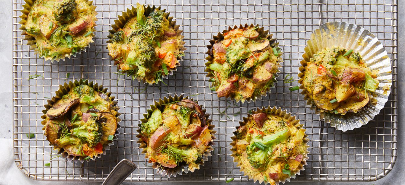 an array of mini frittatas in muffin tin cups with potato and broccoli - vegan scramble