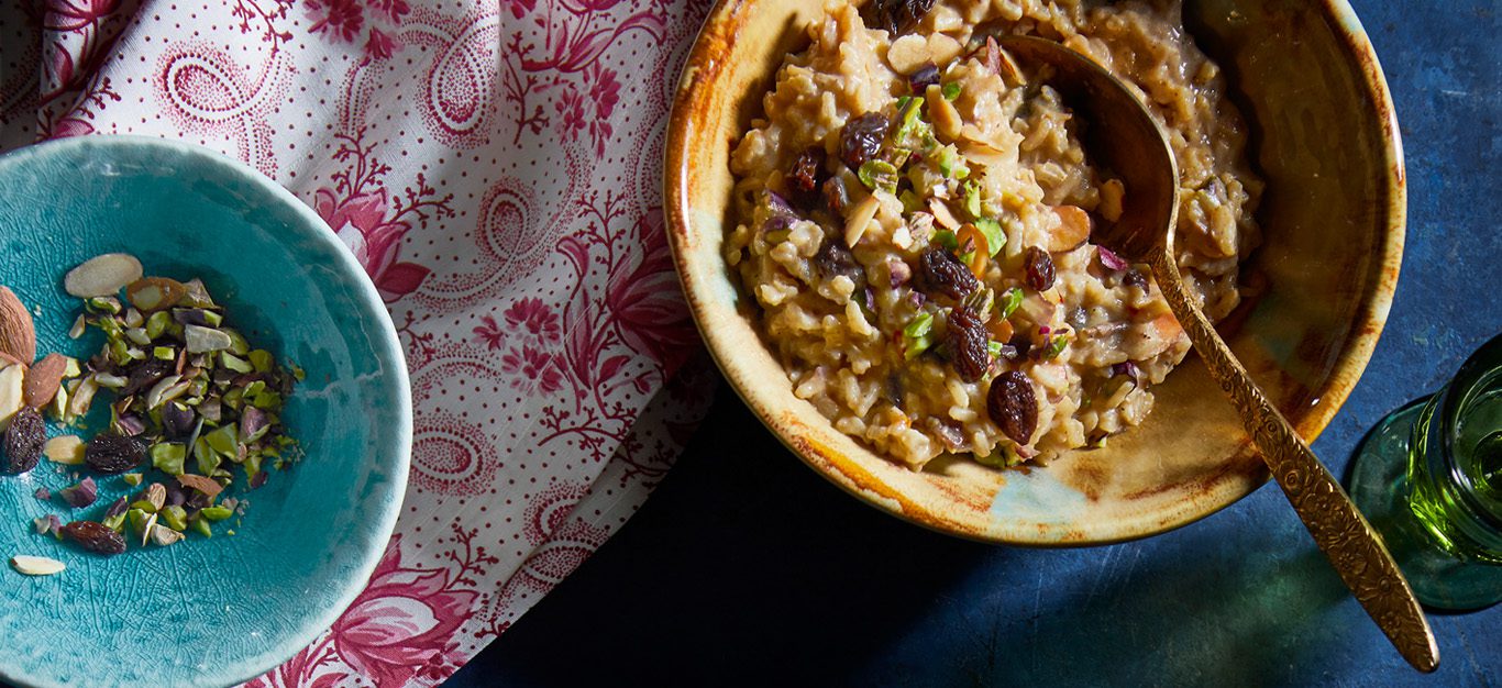 Brown rice kheer in a bowl garnished with raisins and pistachios