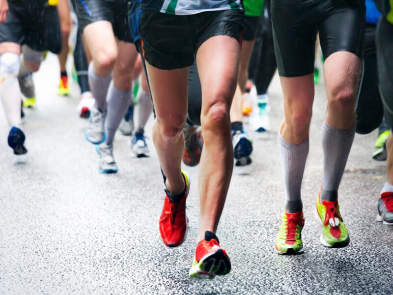 Legs and feet of a crowd of marathon runners in action