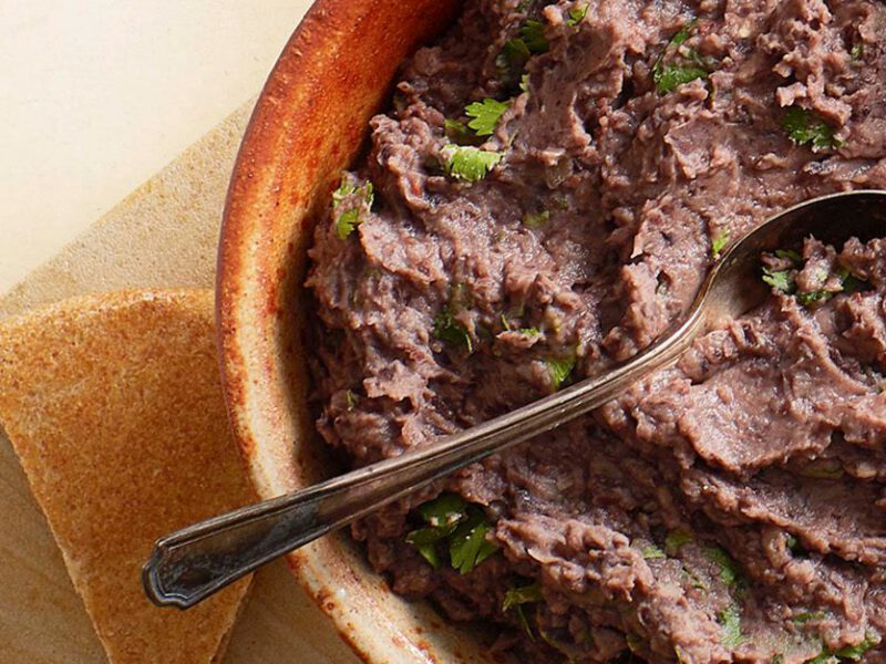 Chipotle Black Bean Dip in a red bowl, with chips on the side