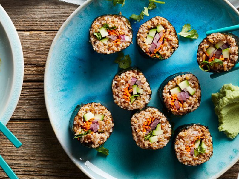 Bulgur Sushi with Zucchini - Held with chopsticks, with a dab of wasabi on the side