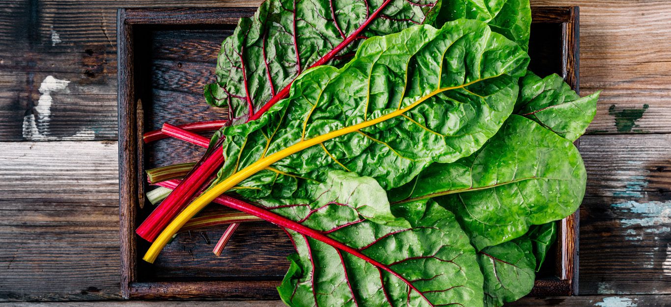 Swiss chard in a wood crate on a wood table